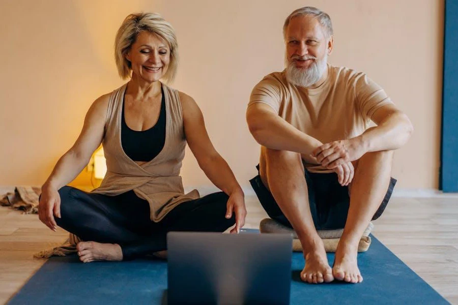 An elderly couple exercising on yoga mats