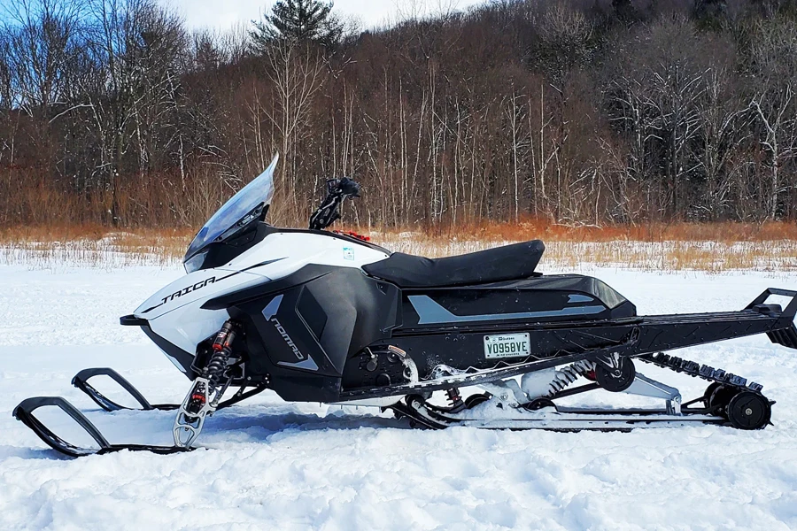 An inactive white electric-powered snowmobile