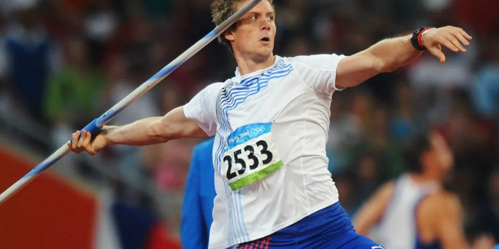 Athlete in a white jersey about to throw a javelin