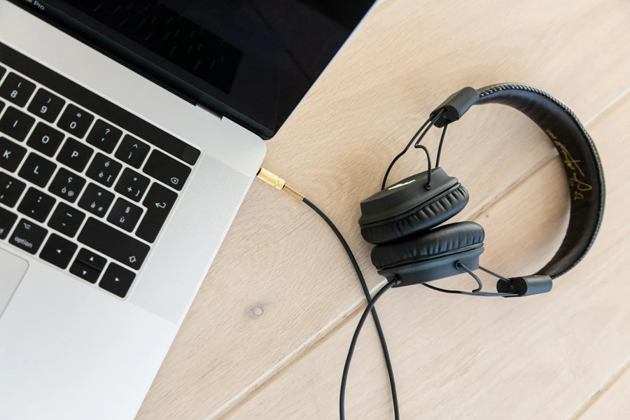 Black Corded Headphones Plugged in Macbook