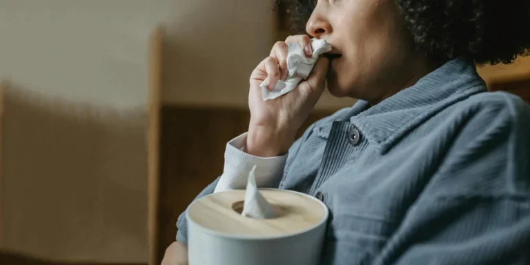 Black crying woman wiping nose with tissue