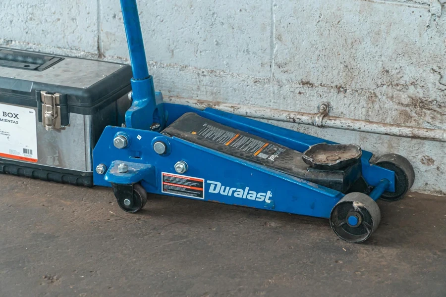 Blue Tool Jack Lift Car For Repair Beside A Tool Box