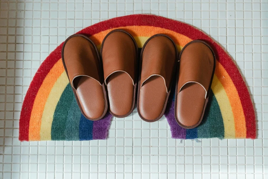 Brown leather slippers on rainbow bathroom mat  