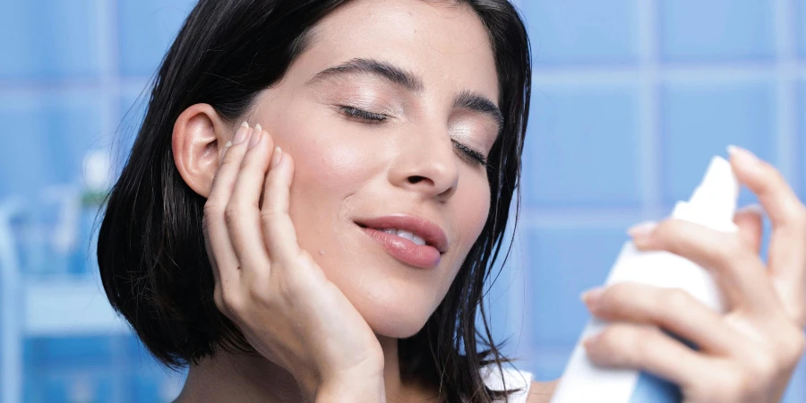 Brunette Woman Applying a Moisturizer on a Face Skin