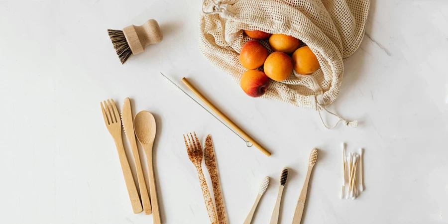 Bunch of peaches in cotton bag placed on table near disposable cutlery