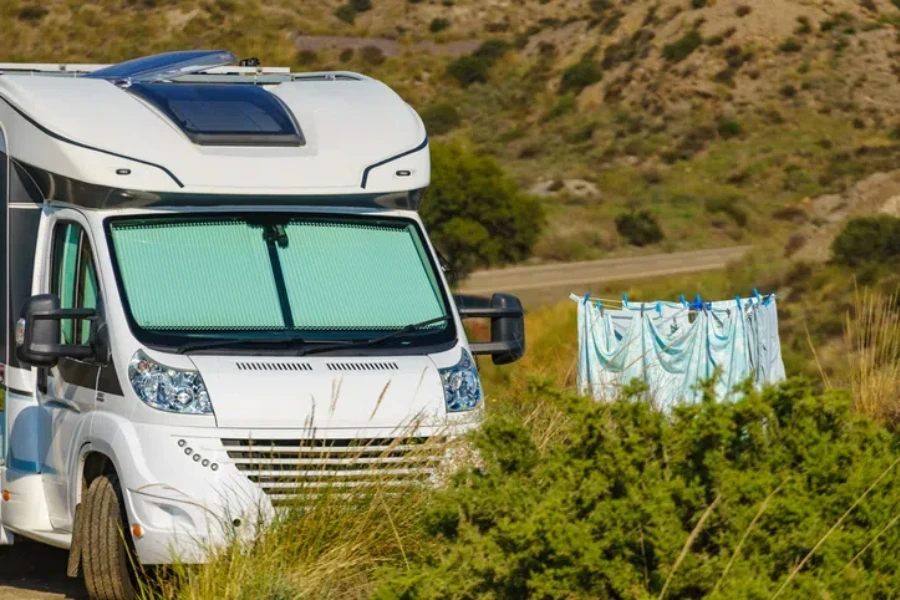 Camper with internal thermal screen blind at window pane.