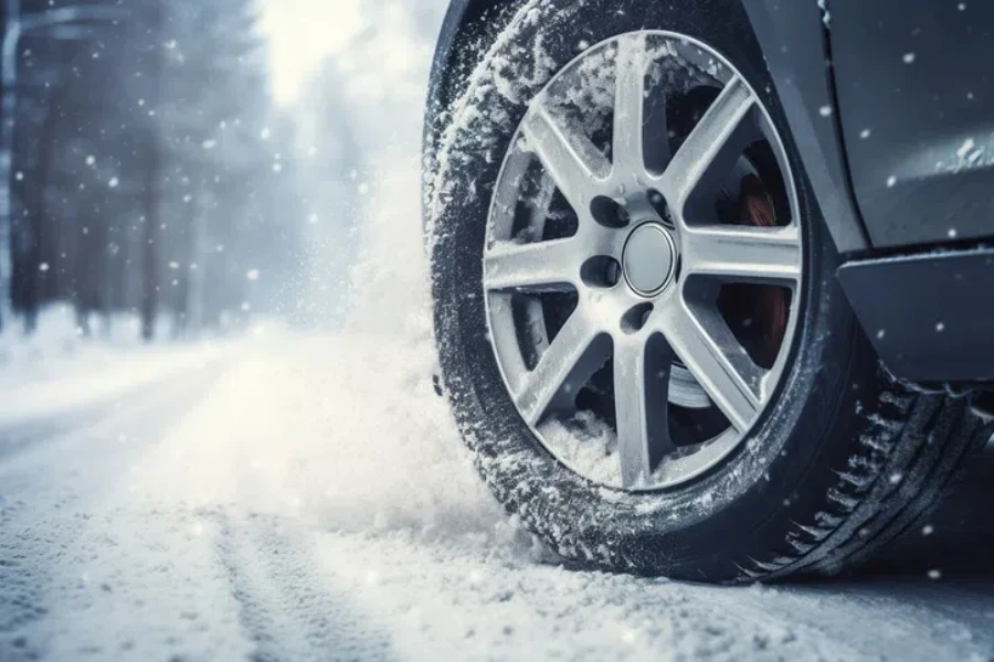 Car on winter tires drives through a snow-covered road