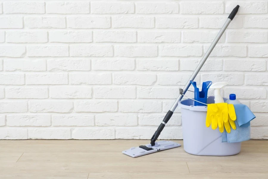 Cleaning items on laminated floor in empty brick wall room