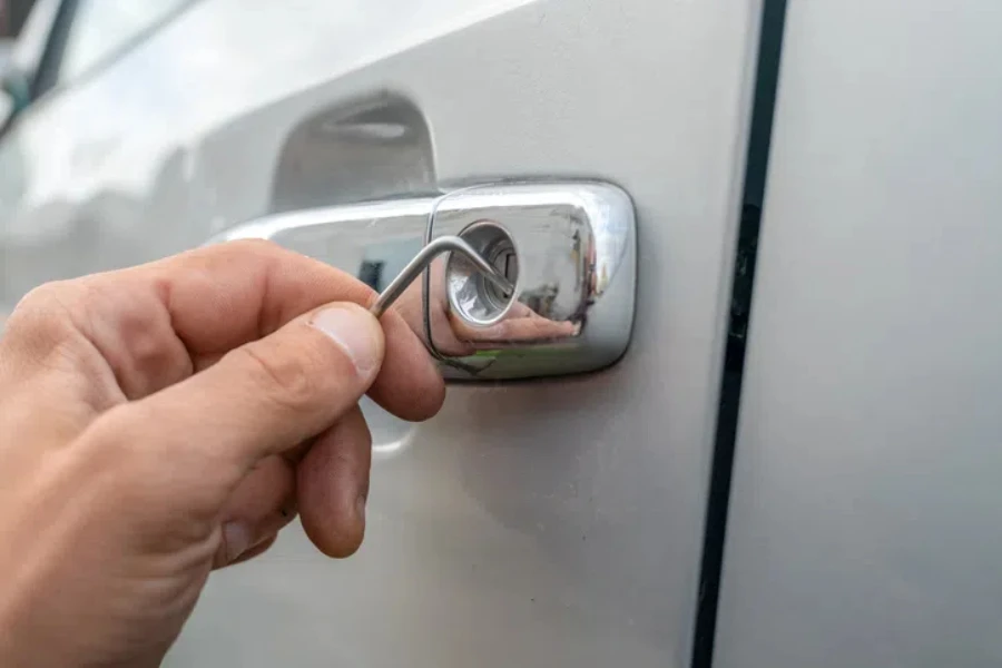 Close - up of a man's hands opening the car with a lock pick