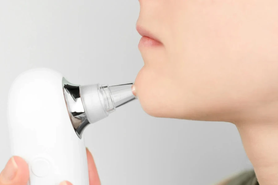 Close-up of using a facial blackhead removal machine