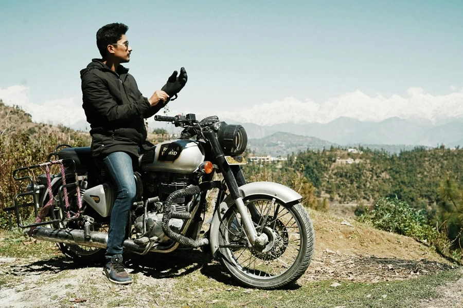 Cool biker on high hill observing landscape