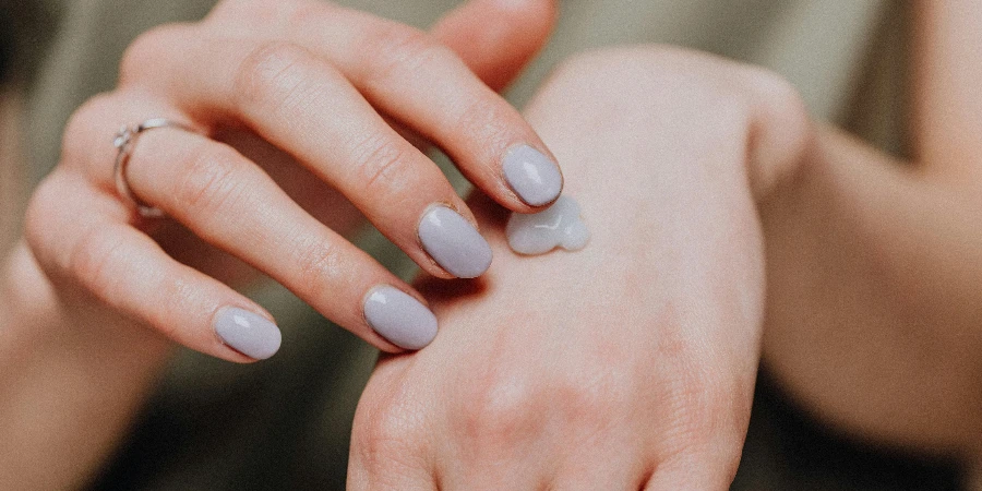 Crop woman with ring applying hand cream