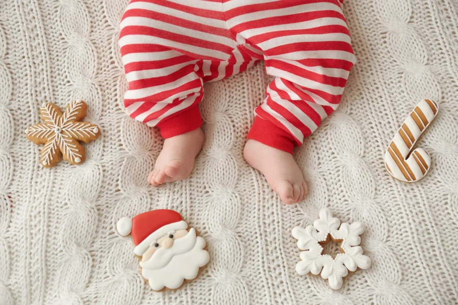 Cute little baby and Christmas cookies on blanket