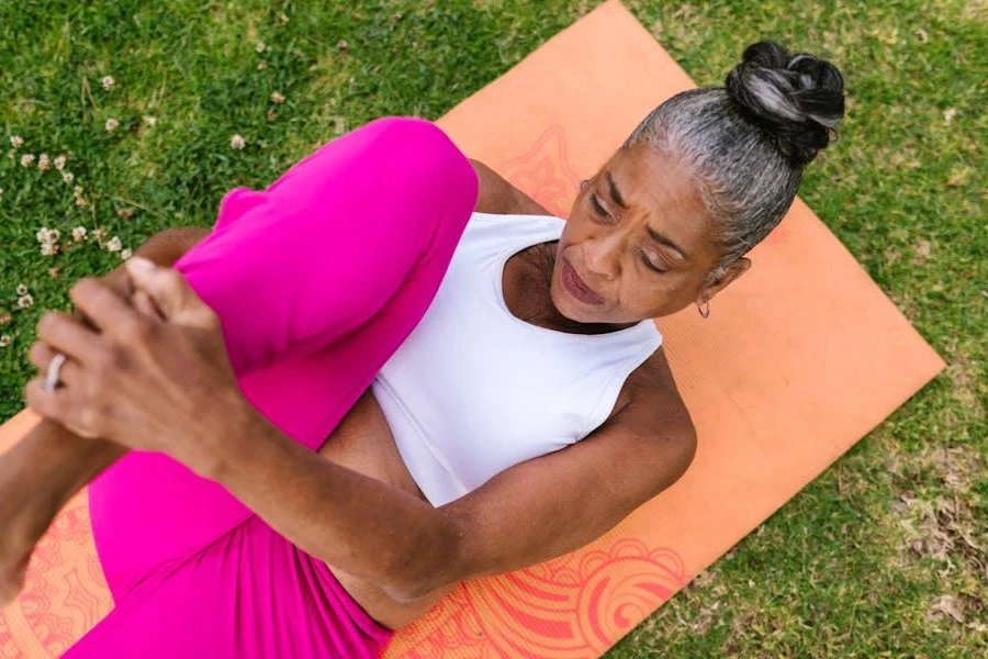 Elderly woman stretching on a yoga mat