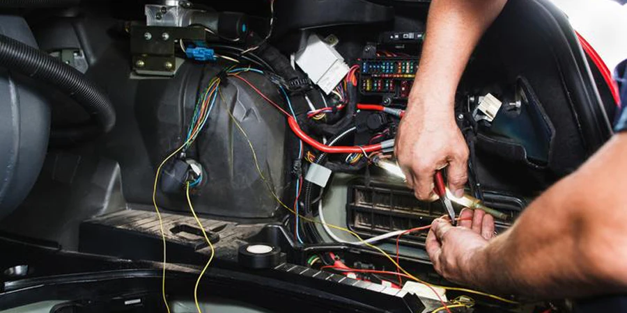 Electrician works with electric block in car