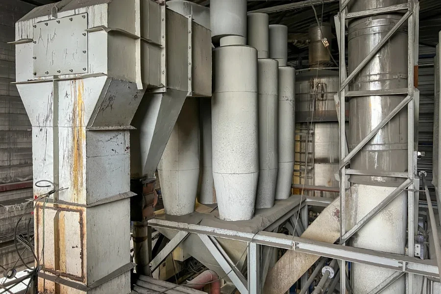 Exhaust gas ducts with a through dust collector and a cyclone battery and an industrial chimney, part inside the building