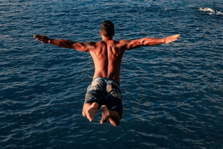 Fit young man jumping into ocean