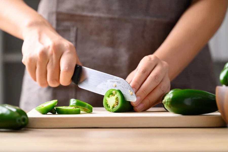 Fresh green Jalapeno chili cutting on wooden board