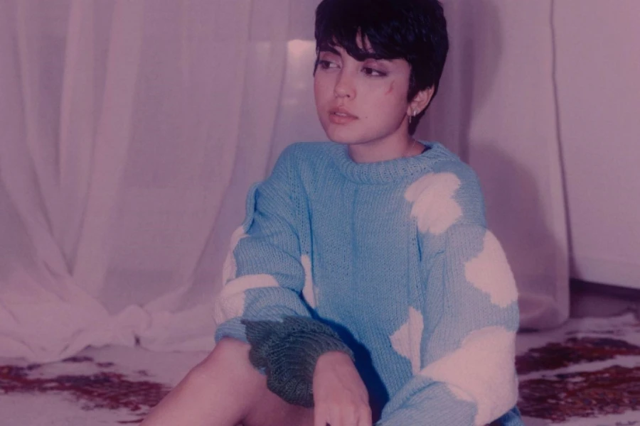 Girl Sitting on a Rug in a Sweater