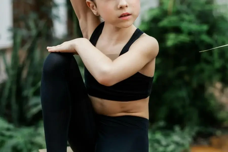 Girl in Black Gym Clothes Sitting in a Garden by Alena Darmel