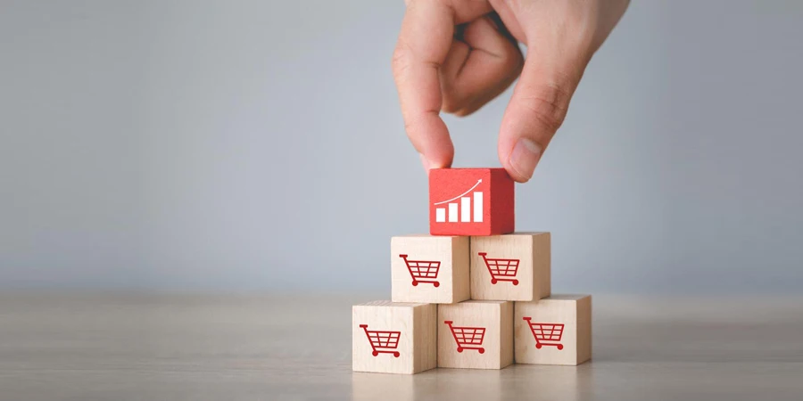 Hand arranging wood block stacking with icon Graph and shopping cart symbol upward direction