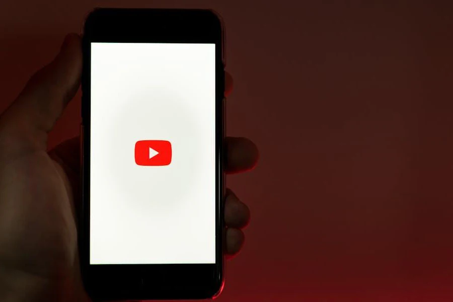 Hand holding a phone with YouTube open