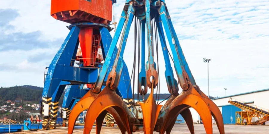 Harbor cranes and a standing grab bucket on the territory of the seaport