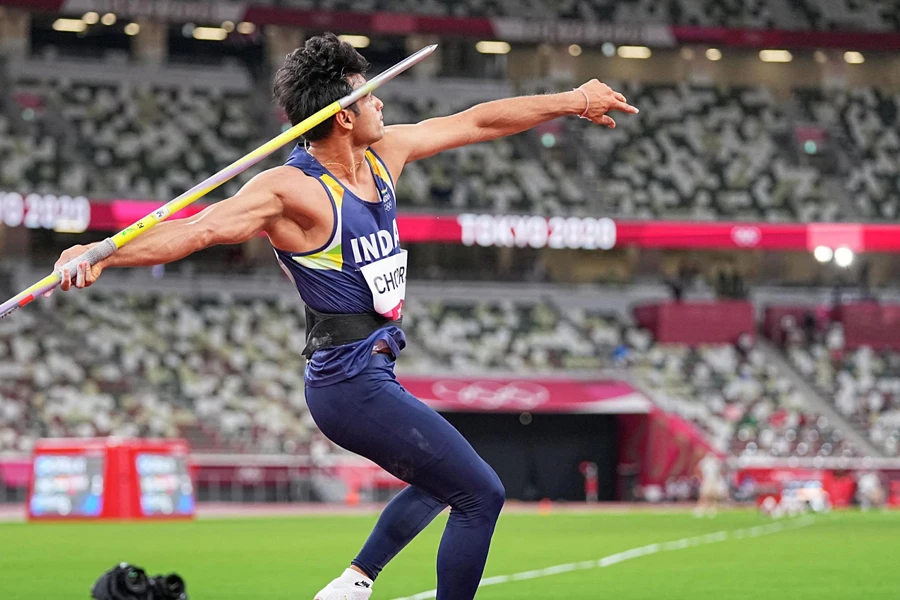 Indian athlete holding a headwind javelin in a stadium