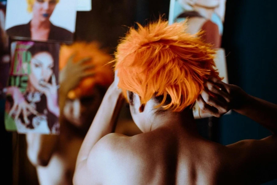 Informal woman putting on orange wig 