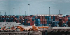 Kontainer antar moda ditumpuk di pelabuhan di sebelah peralatan penanganan