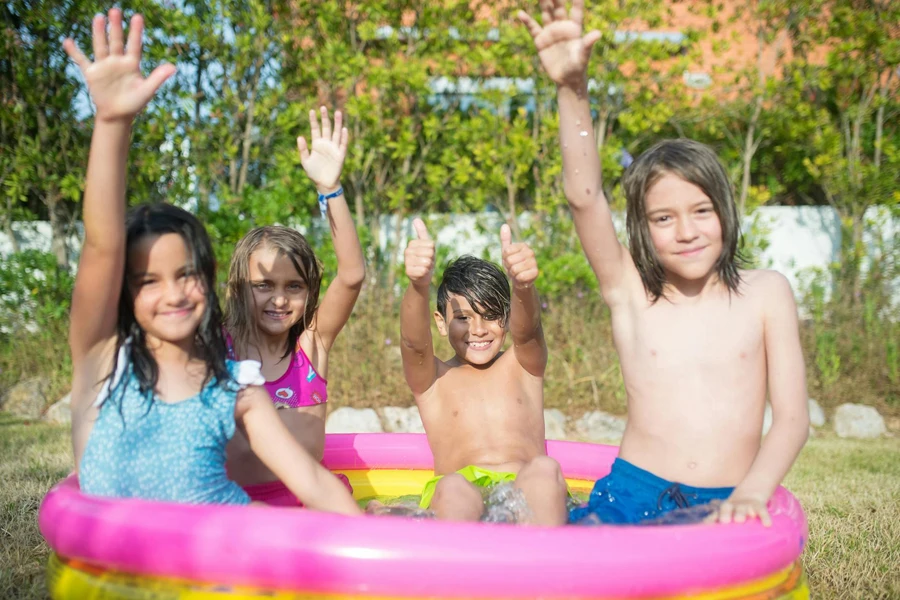 Kids Wearing Swimwear Sitting on Pink and Yellow Inflatable Swimming Pool
