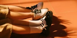 Piernas y zapatos de mujer sentada en el suelo.