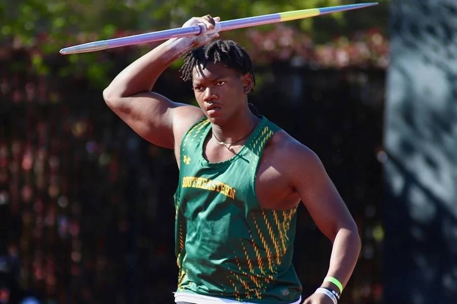 Male athlete holding an Olympic-grade javelin over his head