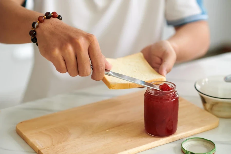 Man Spreading Jam on Bread