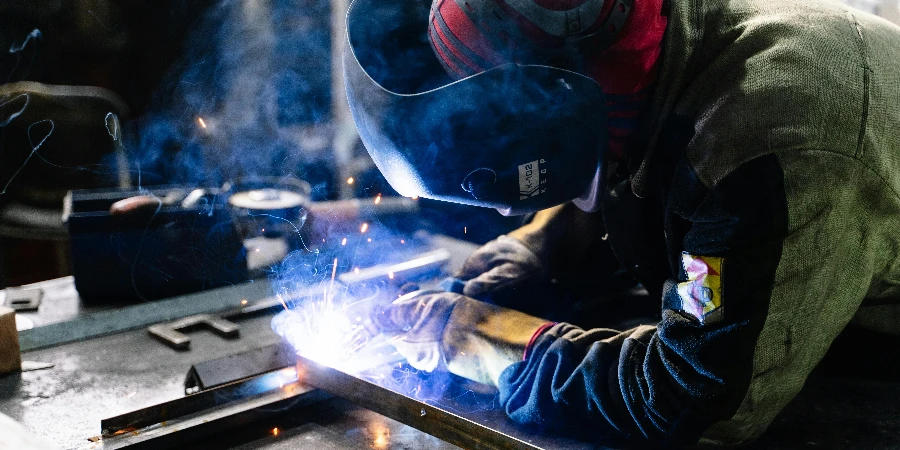 Man Welding Metal Bars by Pavel Chernonogov