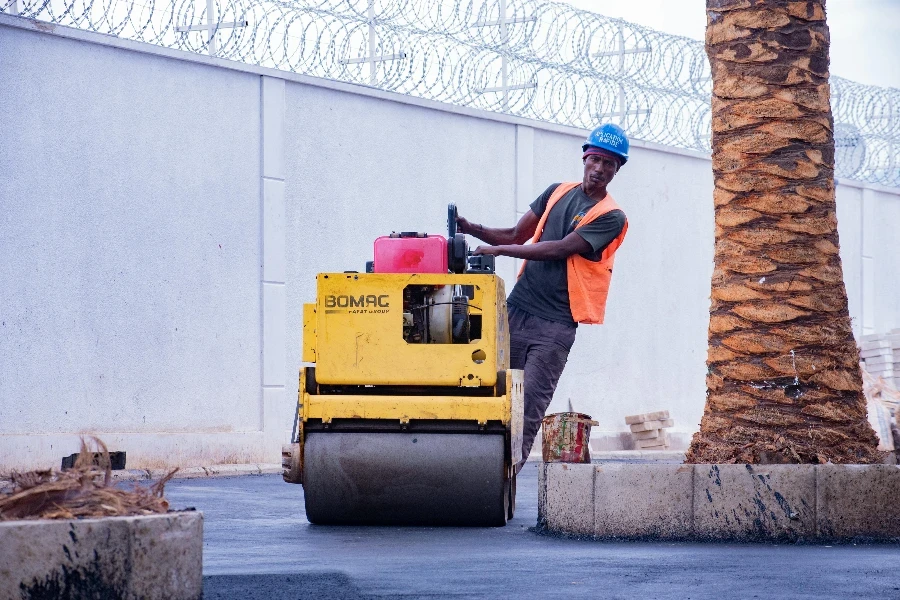 Man Working on Roller on Pavement