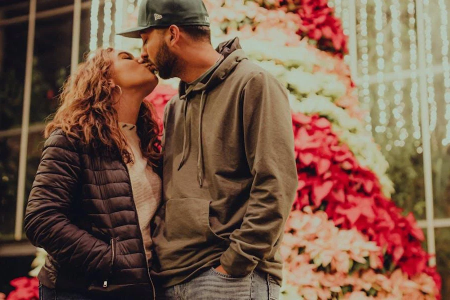 Man and woman kissing in casual Christmas outfits