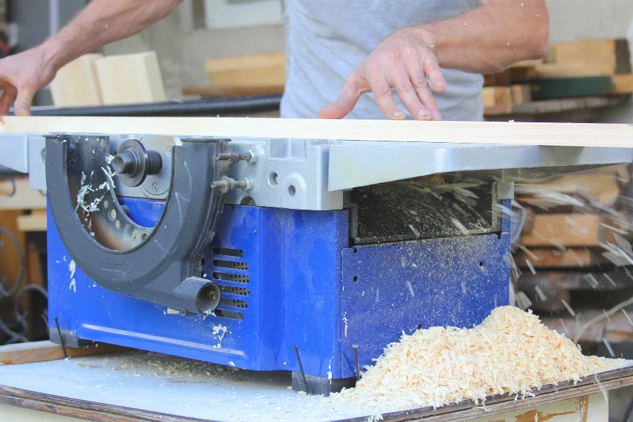 Man hand carpenter processing wooden beams on the machine