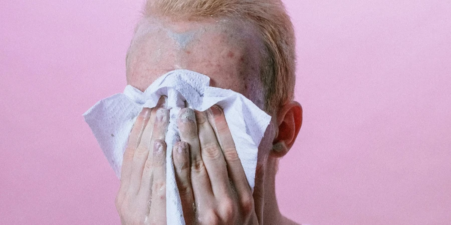 Man in White Crew Neck T-shirt Covering His Face With White Textile