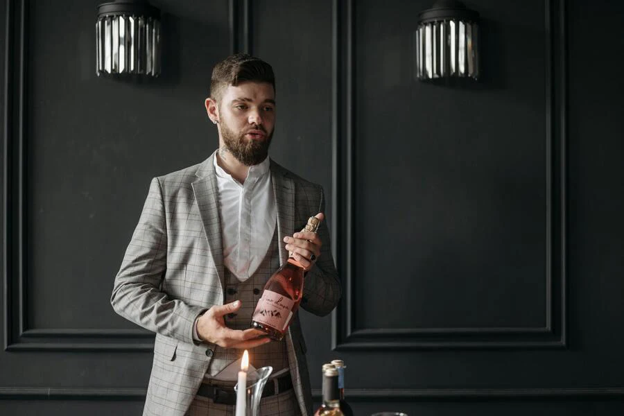 Man in a suit holding a bottle of champagne