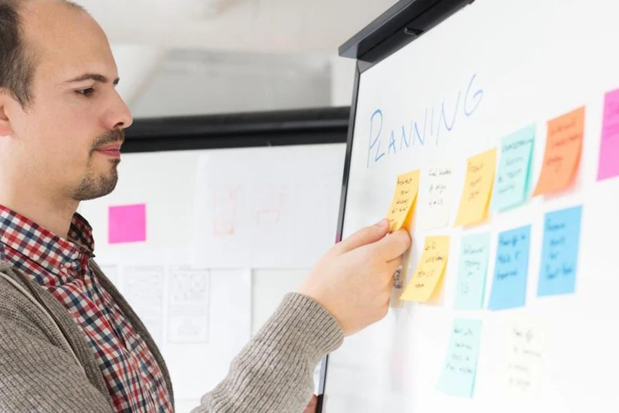 Man planning marketing strategies on a whiteboard