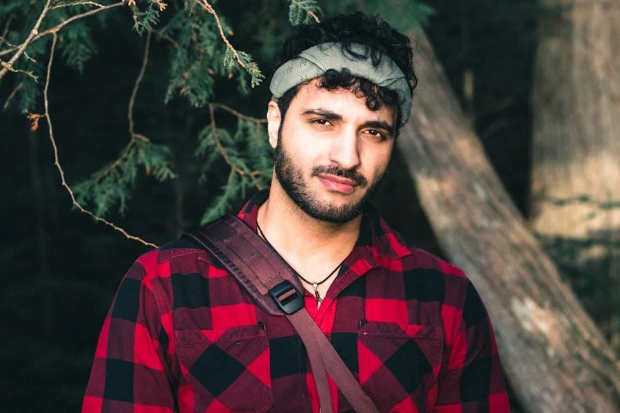 Man resting on a branch in flannel shirt