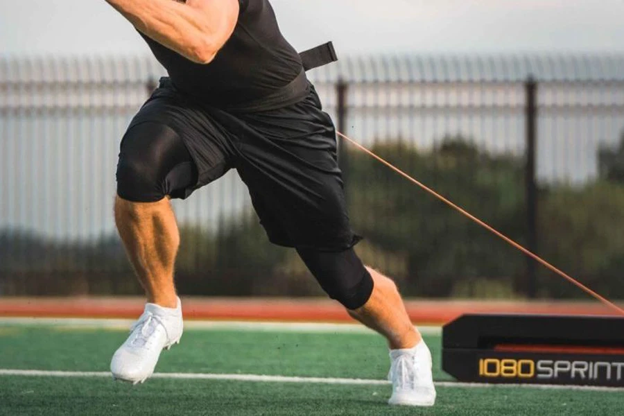 Man sprinting while attached to an overspeed trainer