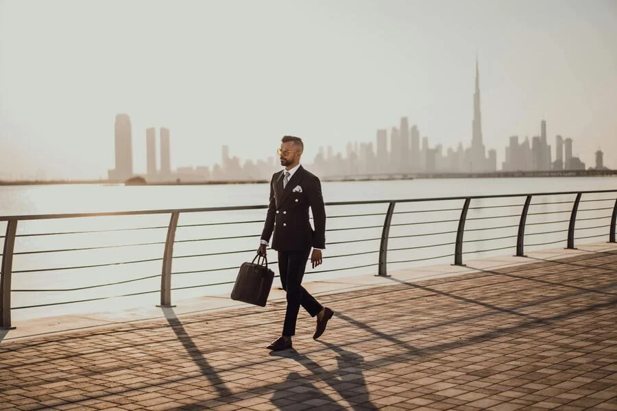 Man walking on the pavement in a black suit