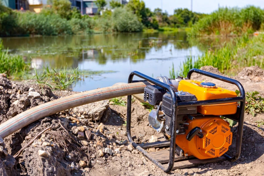 Orange motor pump with long hose for filling tank