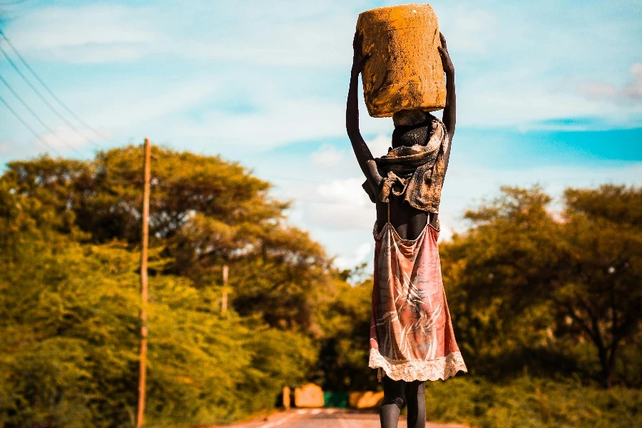 Person Carrying Container on the Head on Road