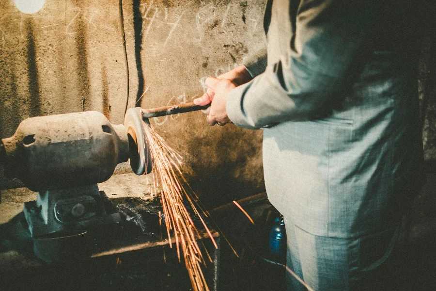 Person Grinding Metal on Bench Grinder