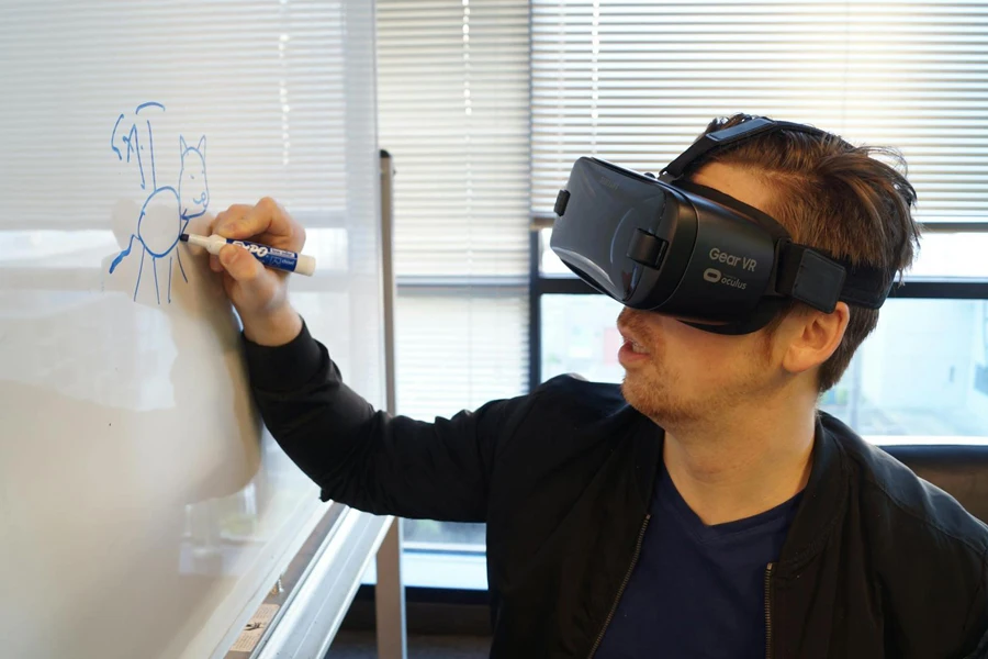 Person Wearing Black Vr Box Writing On White Board 