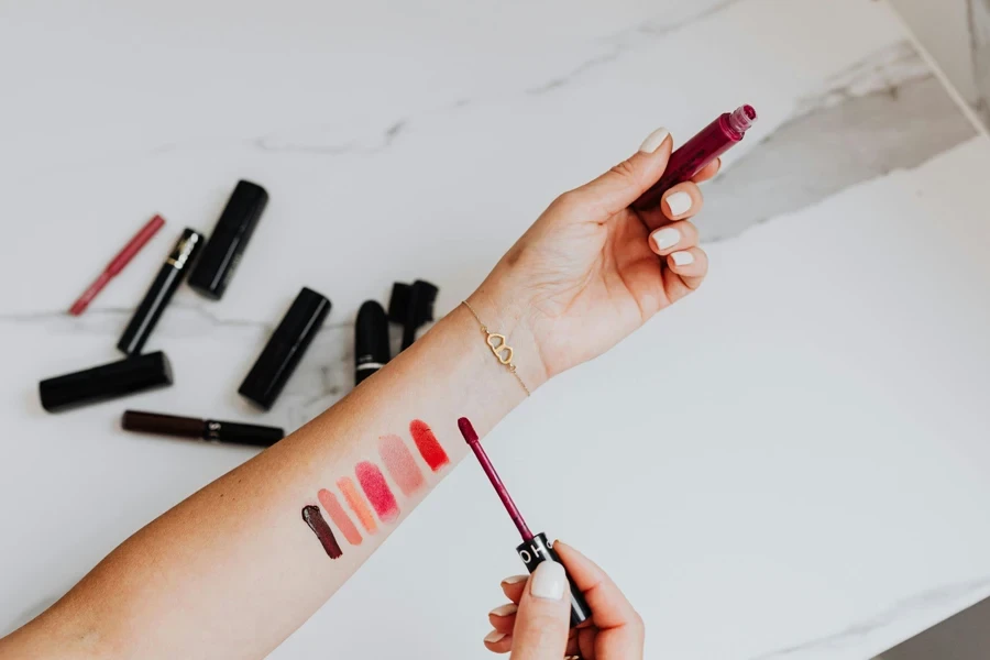 Person applying different lipstick products on her arm