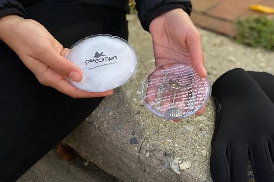 Person holding two reusable hand warmers